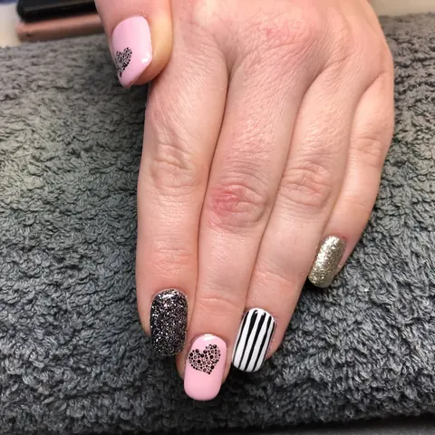 Sa pose : un cœur, des rayures noires et un ongle à paillettes